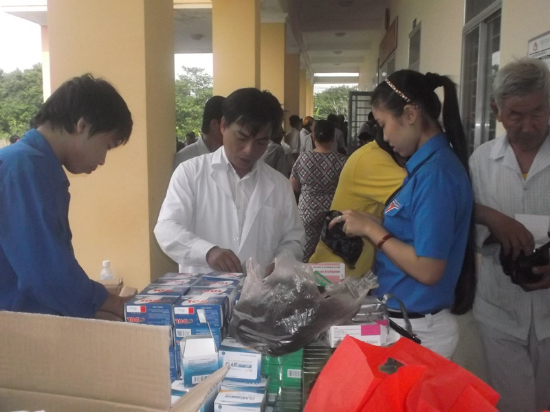 Bác sĩ Thắng đang phát thuốc và tư vấn cho người dân