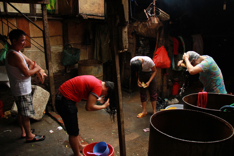 Những nữ lao động ở bãi rác gội đầu trước khi nghỉ ăn trưa. Ảnh: Trường Phong