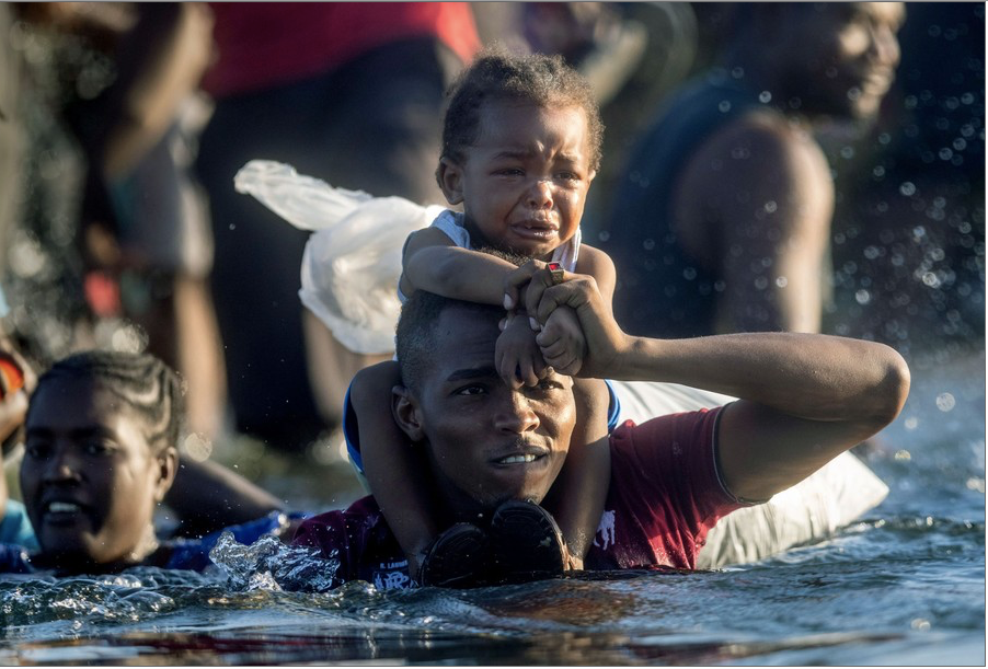 22. Người tị nạn Haiti ở Del Rio, bang Texas, Mỹ, vượt sông Rio Grande để quay lại Mexico ngày 20/9. Khi giới chức Mỹ bắt đầu trục xuất người tị nạn trở lại, hàng ngàn người phải chờ trong lều tạm dưới gầm cây cầu quốc tế ở Del Rio trong khi nhiều người khác vượt sông để tránh bị trục xuất. (Ảnh: Getty Images)