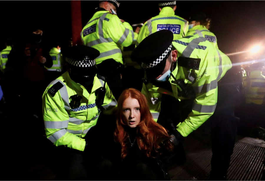 9. Cảnh sát bắt giữ một phụ nữ trong nhóm biểu tình ở Clapham, Common Bandstand, để phản đối vụ một cảnh sát bắt cóc, hãm hiếp và sát hại cô Sarah Everad ở London, Anh, ngày 13/3. (Ảnh: Reuters)