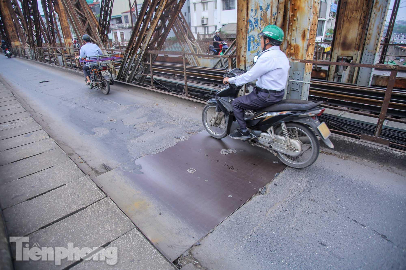 Mặt cầu được vá tạm bằng những tấm sắt. Mặt cầu được vá tạm bằng những tấm sắt.