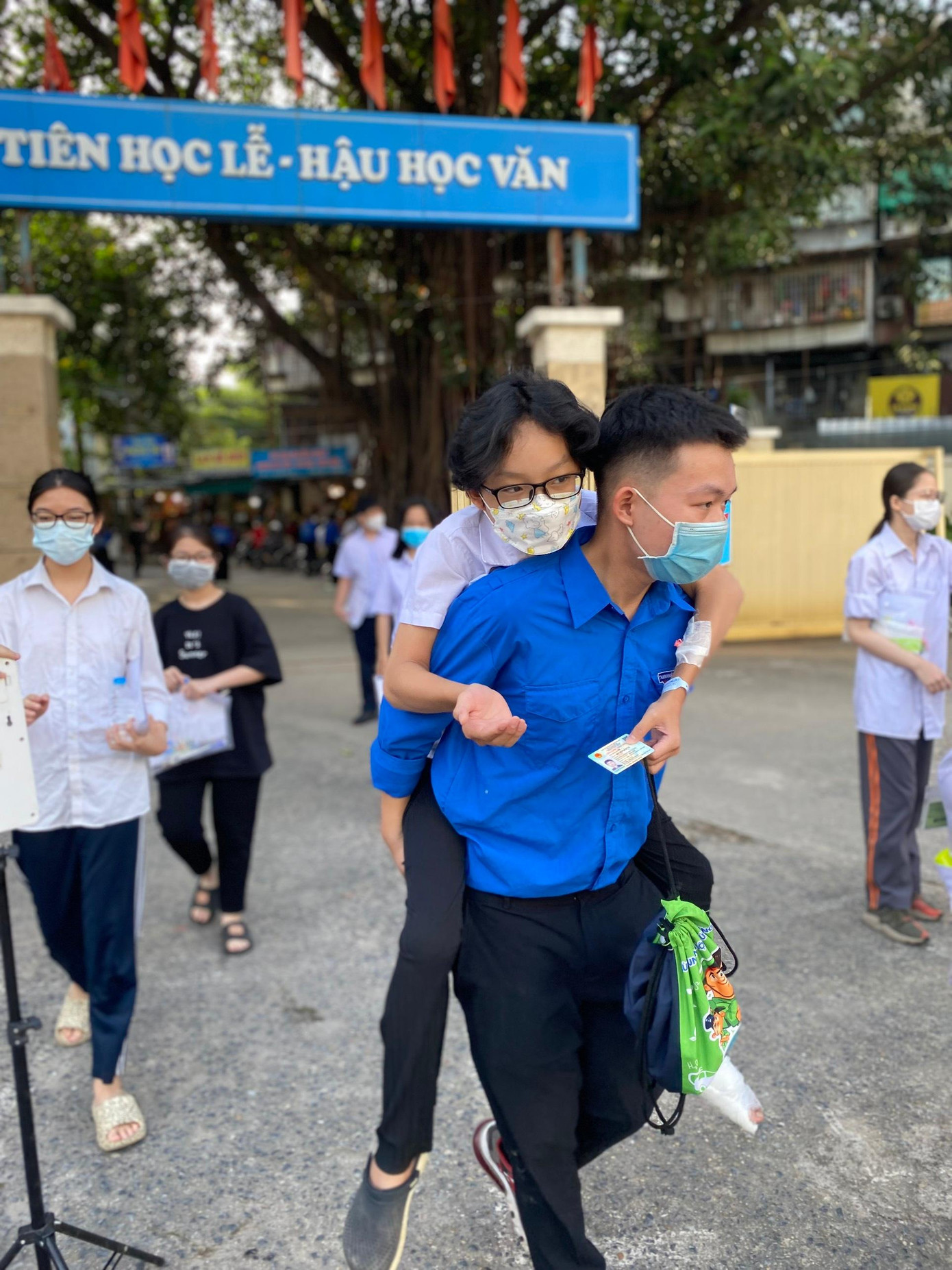 Em Nguyễn Hoàng Bảo Long, học sinh trường THCS Lý Thường Kiệt (Hà Nội) bị bỏng xe phải bó bột, các tình nguyện viên hỗ trợ đưa vào phòng thi tại điểm thi Việt Nam - Angieri