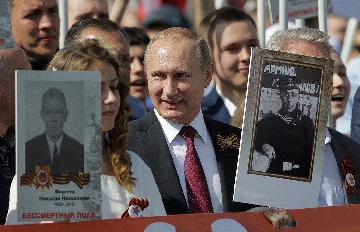 Tổng thống Vladimir Putin cầm bức chân dung của cha - ông Vladimir Spiridonovich Putin, người từng chiến đấu trong Thế chiến II - khi tham gia cuộc tuần hành Trung đoàn bất tử hồi năm 2016. Ảnh: Tass