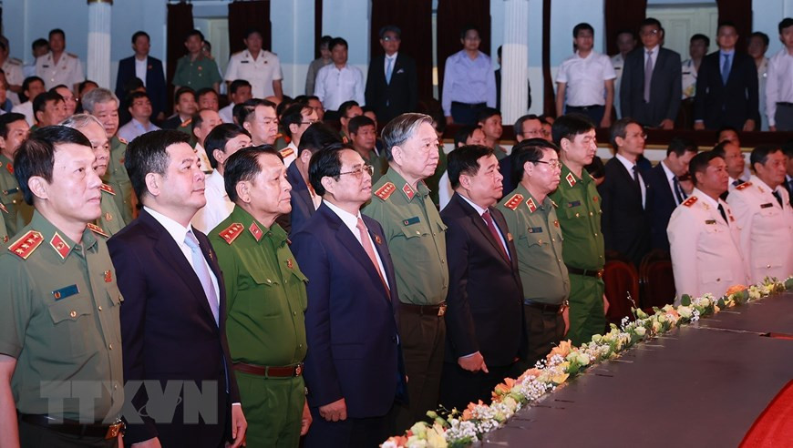 Thủ tướng Phạm Minh Chính và các đại biểu thực hiện nghi thức chào cờ tại lễ kỷ niệm 70 năm Ngày truyền thống lực lượng An ninh Kinh tế. (Ảnh: Dương Giang/TTXVN)