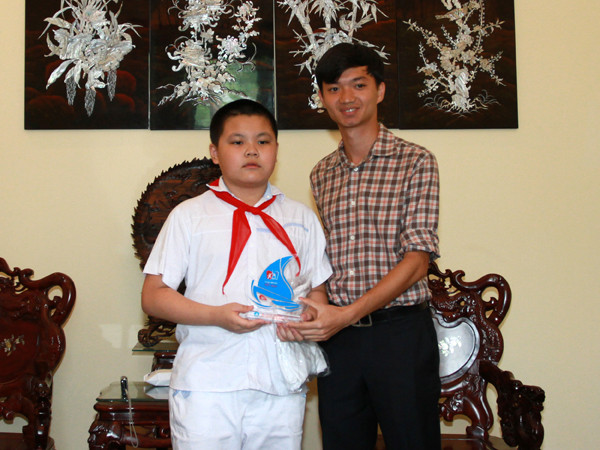 Anh Nguyễn Minh Triết, Giám đốc Hỗ trợ và phát triển sinh viên Việt Nam trao quà cho em Đức