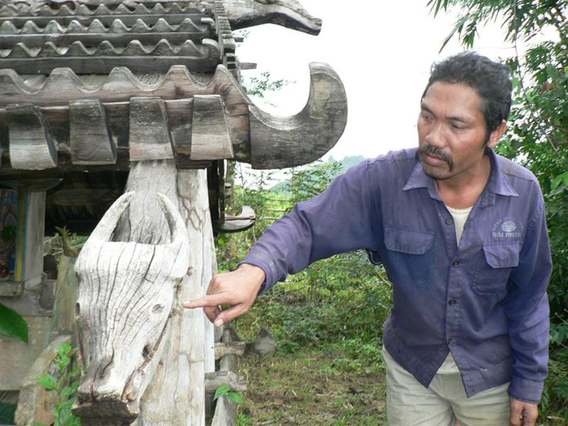 Già làng Briu Ngà bên ngôi nhà mồ. Ảnh: Nguyễn Huy