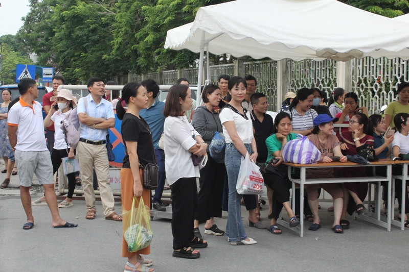 Người nhà các thí sinh chờ đợi phía bên ngoài trường thi sáng 22/5