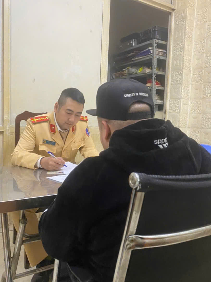 CSGT làm việc với tài xế ô tô và người ngồi trên nắp ca-pô.