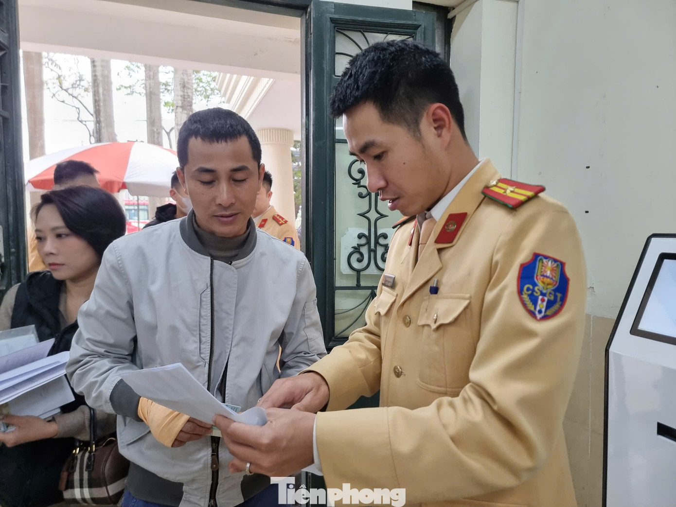Lực lượng CSGT hướng dẫn người dân làm thủ tục cấp, đổi giấy phép lái xe.