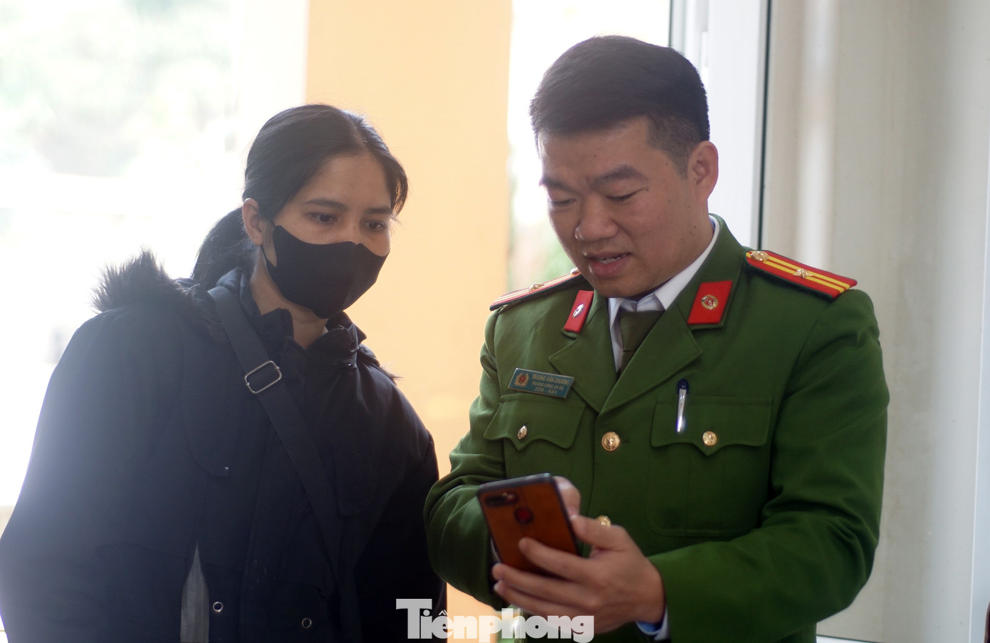 Cán bộ Công an hướng dẫn người dân sử dụng ứng dụng VNeID. Ảnh: Thanh Hà