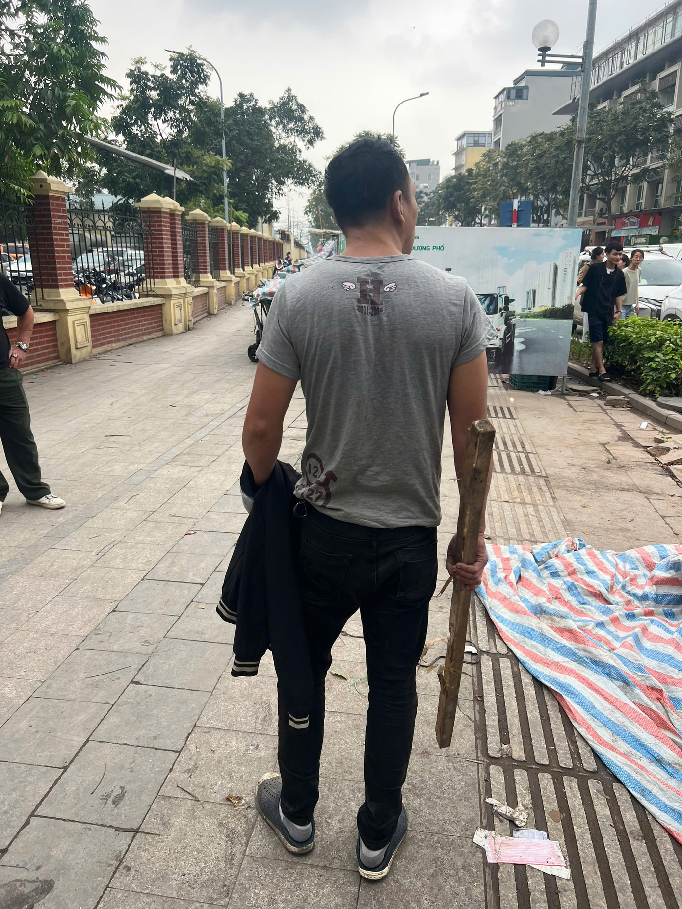 Đối tượng cầm theo cây gậy tấn công người đi đường.