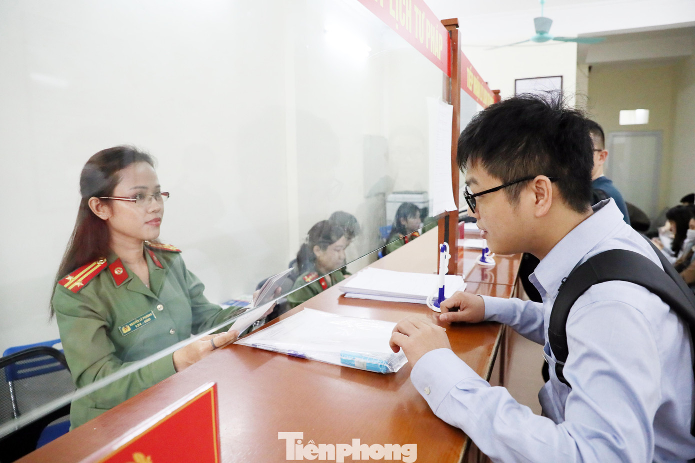 Trung tá Nguyễn Lê Phương trao đổi với người làm thủ tục. Trung tá Nguyễn Lê Phương trao đổi với người làm thủ tục.
