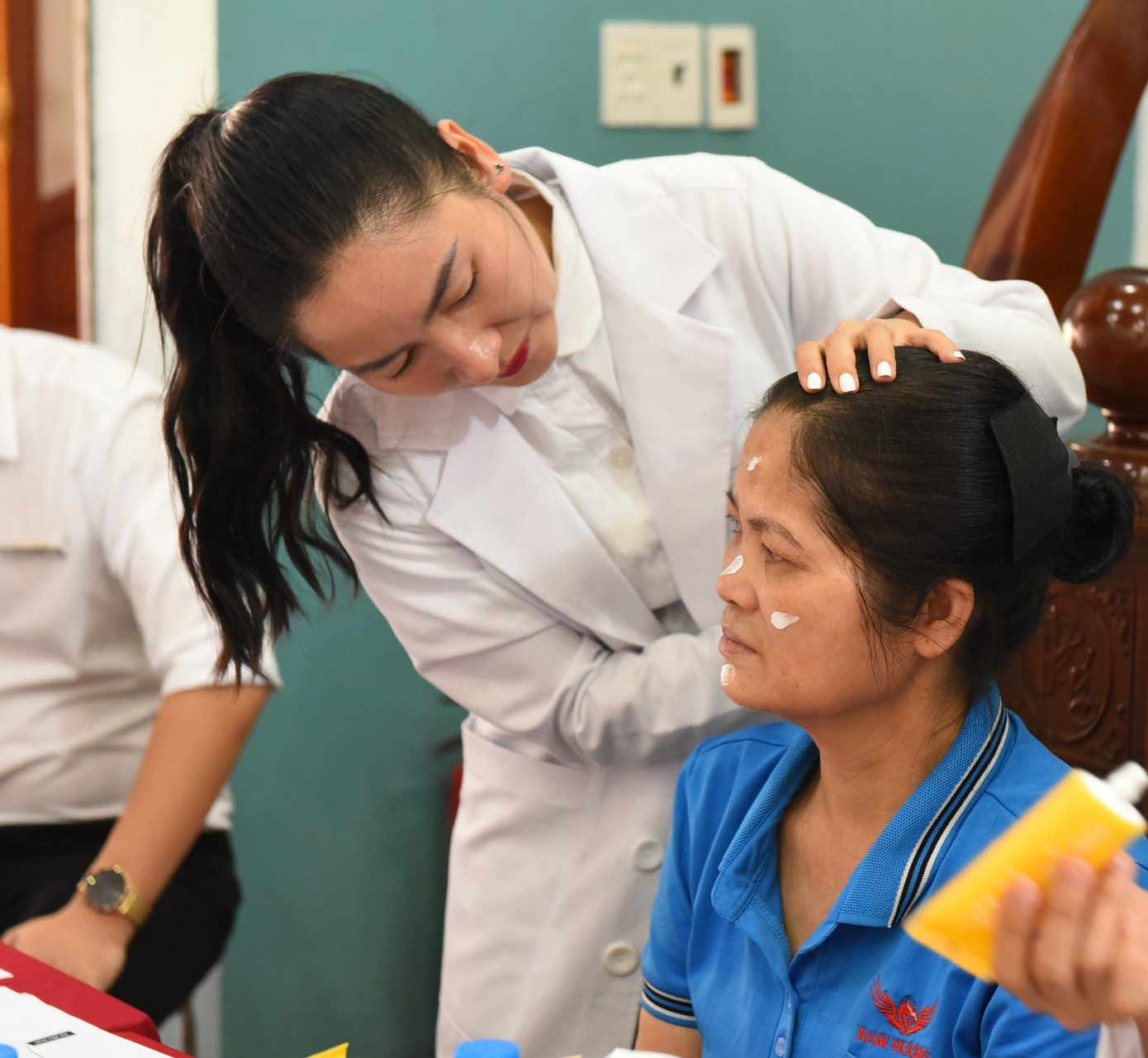 Các chuyên gia soi da và tư vấn chăm sóc da cho các nữ công nhân xưởng may Nam Hương.