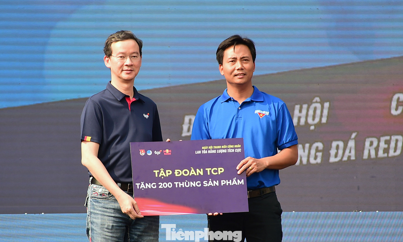 Ông Saravoot Yoovidhya - CEO Tập đoàn TCP trao biểu trưng cho anh Nguyễn Đức Tiến - Phó Bí thư thường trực Thành Đoàn Hà Nội, về hỗ trợ 200 thùng sản phẩm đến thanh niên công nhân Hà Nội. Ảnh: Xuân Tùng