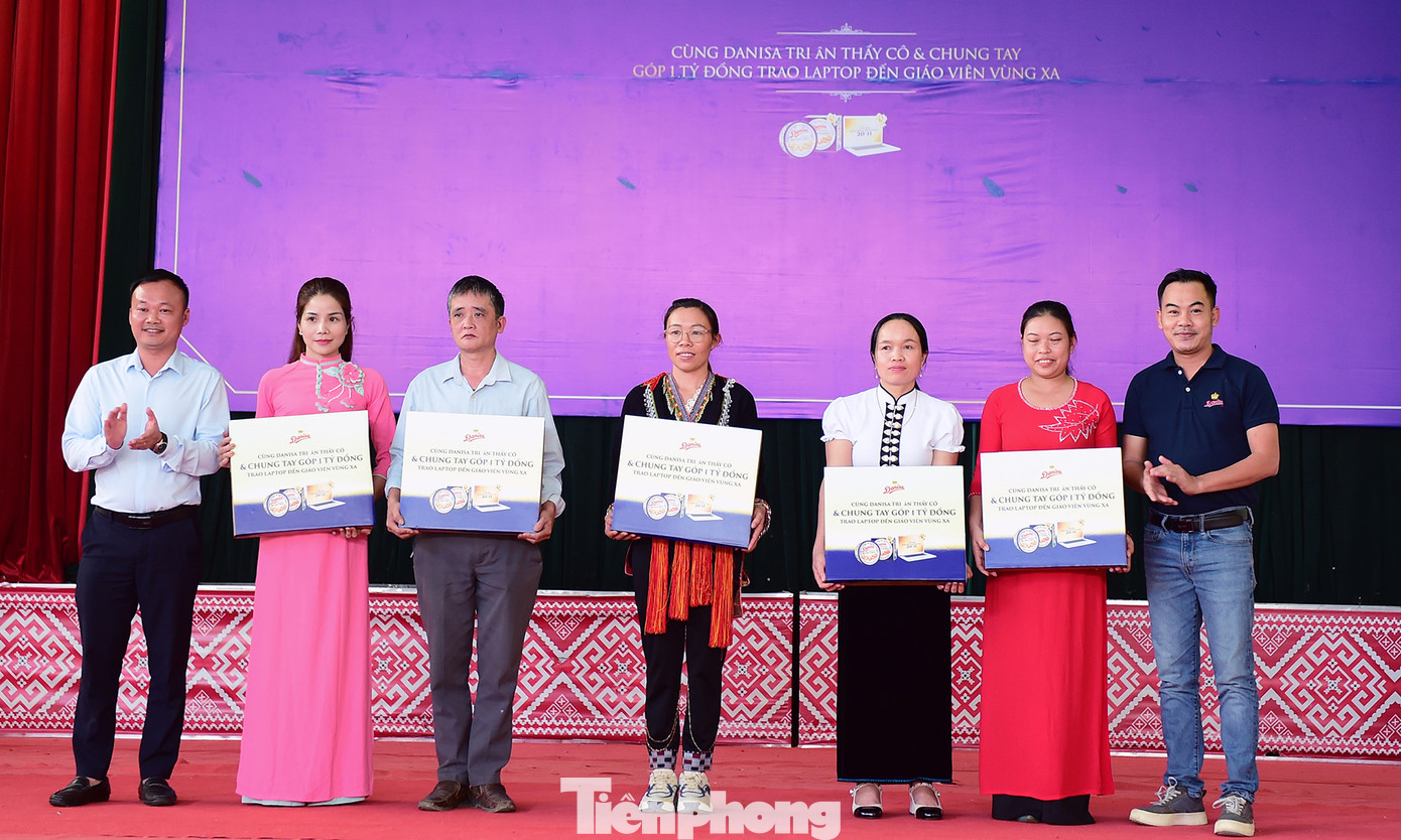 Anh Phạm Tuấn Anh - Phó Trưởng Ban Thanh niên Báo Tiền Phong, và đại diện nhãn hàng Danisa Việt Nam, trao tặng máy tính đến các thầy cô. Ảnh: Xuân Tùng