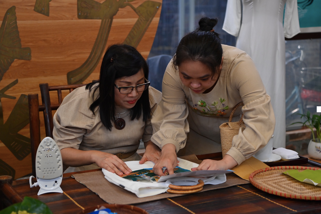 Phu nhân Lê Thị Bích Trân học cách làm sản phẩm từ vải vụn. (Ảnh: Nhật Huy) Phu nhân Lê Thị Bích Trân học cách làm sản phẩm từ vải vụn. (Ảnh: Nhật Huy)