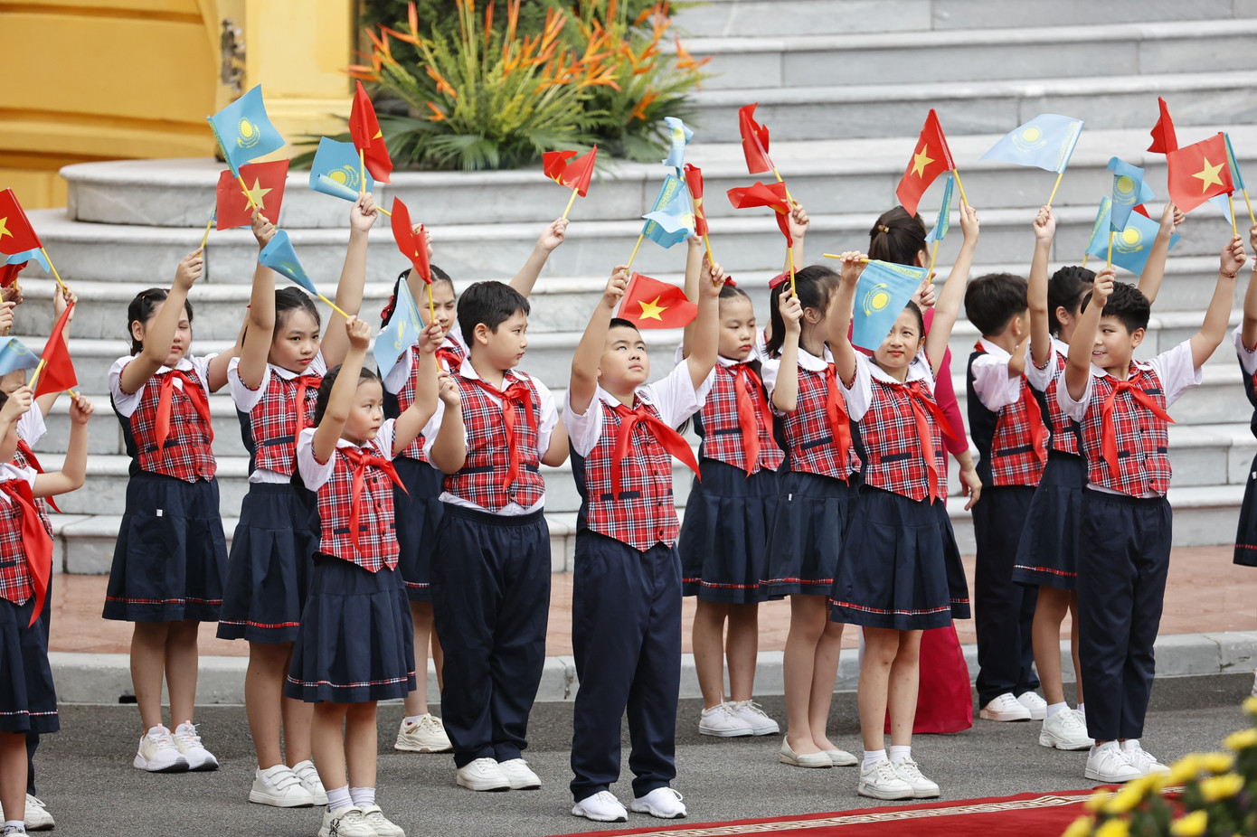 Các em thiếu nhi Hà Nội vẫy quốc kỳ Việt Nam và Kazakhstan chào đón Tổng thống Kassym Jomart Tokayev. (Ảnh: Như Ý)