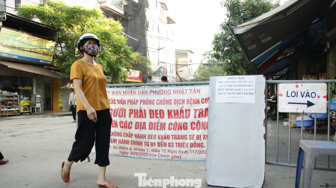 Tại đây, rào chắn được quây khắp các lối ra vào chợ, cùng với bảng hiệu tuyên truyền.