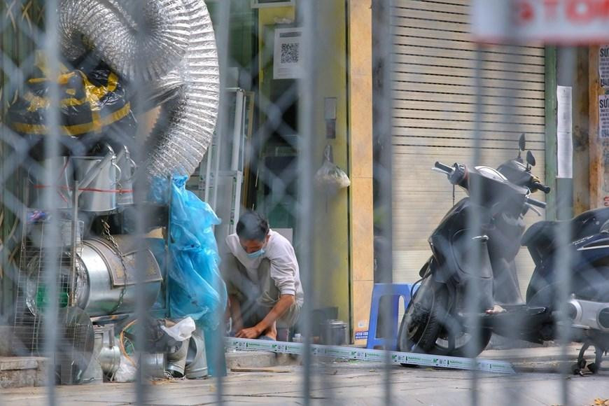 Người dân trong khu vực cách ly tại phố Hàng Thiếc (phường Hàng Gai, quận Hoàn Kiếm). (Ảnh: Tuấn Đức/TTXVN)