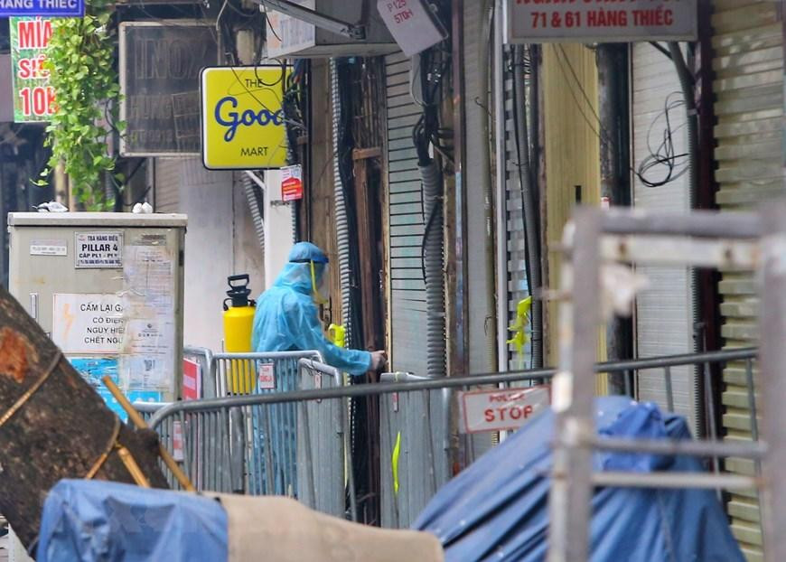 Nhân viên y tế phun khử khuẩn tại các hộ gia đình trên phố Hàng Thiếc (phường Hàng Gai, quận Hoàn Kiếm). (Ảnh: Tuấn Đức/TTXVN)
