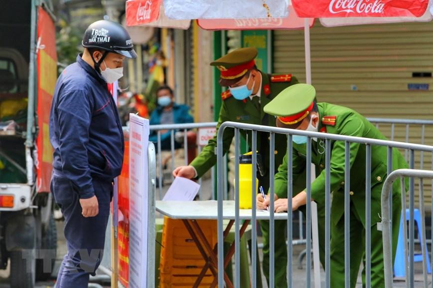 Lực lượng chức năng kiểm soát việc tiếp tế tại phố Hàng Thiếc (phường Hàng Gai, quận Hoàn Kiếm). (Ảnh: Tuấn Đức/TTXVN)