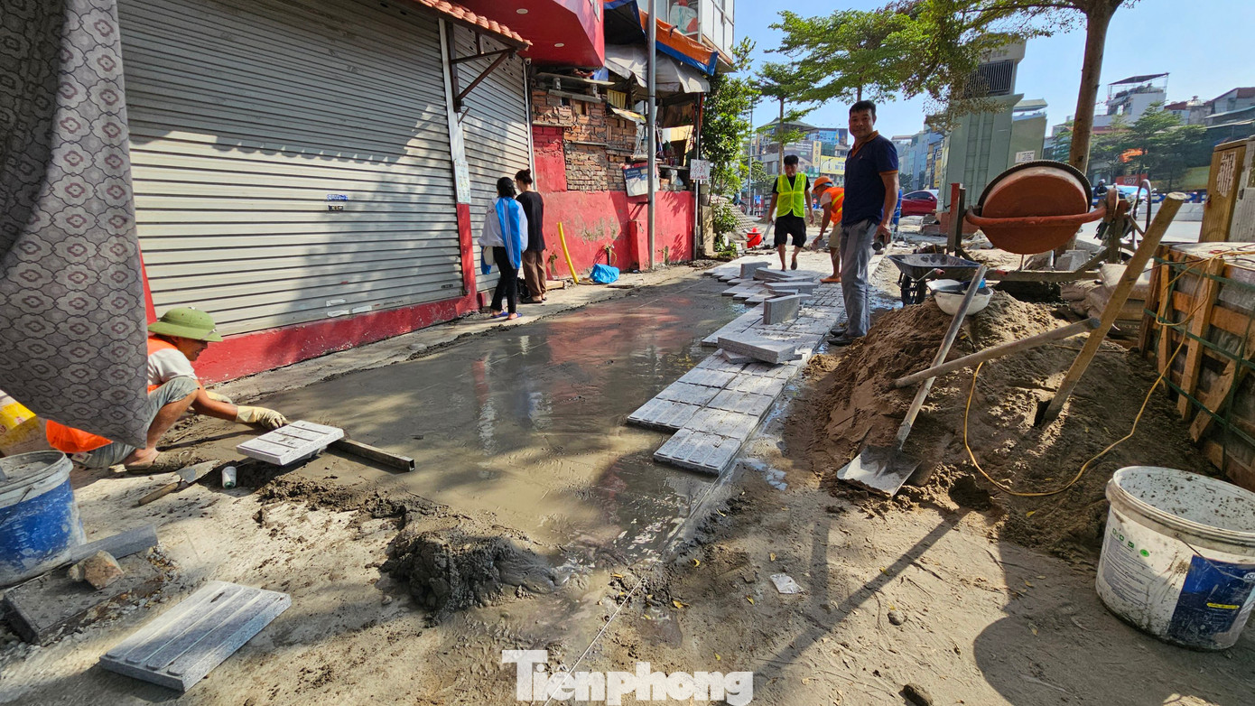 Hàng chục công nhân đang thi công, bóc lớp gạch cũ của vỉa hè để lát đá mới.