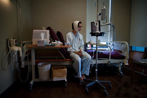 Một nam thanh niên tỉnh dậy sau ca phẫu thuật. Anh phải đảm bảo quy trình vệ sinh, băng bó sau phẫu thuật để tránh biến chứng