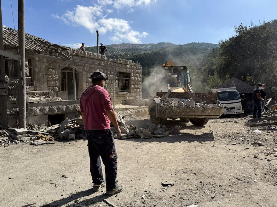 Một người đứng trước chiếc máy xúc đang dọn dẹp hiện trường vụ không kích của Israel ở thị trấn Aitou, nơi dân số chủ yếu là người Cơ đốc giáo, ngày 15/10. (Ảnh: Reuters) Một người đứng trước chiếc máy xúc đang dọn dẹp hiện trường vụ không kích của Israel ở thị trấn Aitou, nơi dân số chủ yếu là người Cơ đốc giáo, ngày 15/10. (Ảnh: Reuters)