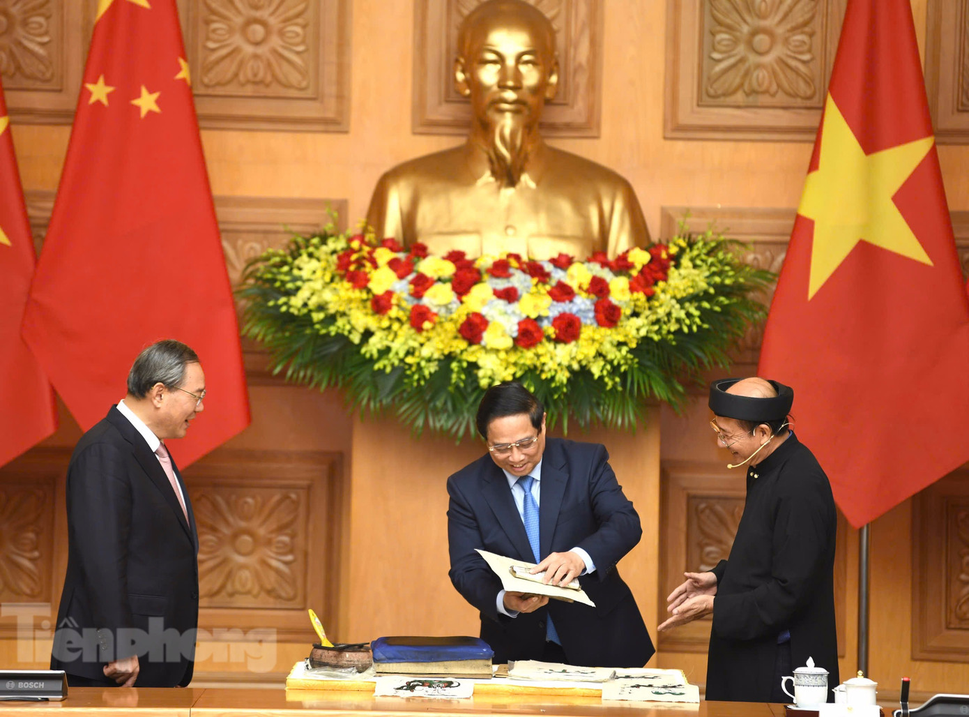 Thủ tướng Phạm Minh Chính thử làm bức tranh “Cưỡi trâu thổi sáo” theo hướng dẫn của nghệ nhân. (Ảnh: Như Ý)