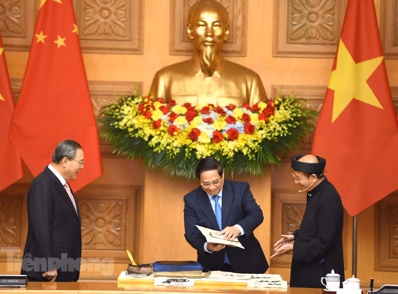 Thủ tướng Phạm Minh Chính thử làm bức tranh “Cưỡi trâu thổi sáo” theo hướng dẫn của nghệ nhân. (Ảnh: Như Ý)