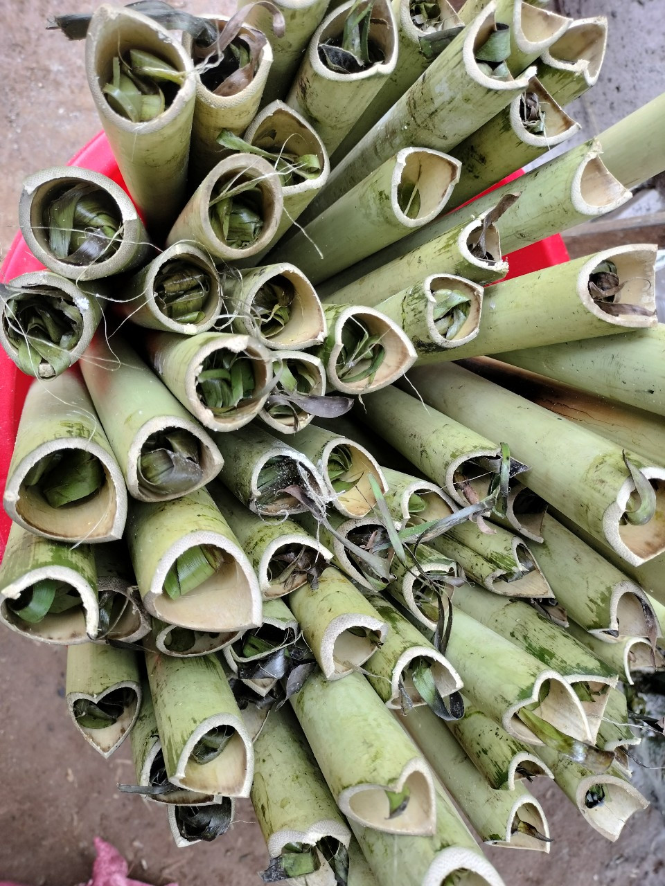 Sau công đoạn ngâm và làm sạch, gạo được trộn với nước lá dứa trước khi dồn vào ống nứa để cơm thơm và có màu xanh bắt mắt. Trước khi đặt lên bếp nướng, nút chặt ống cơm bằng lá dứa để giữ nước và mùi thơm của cơm bên trong.