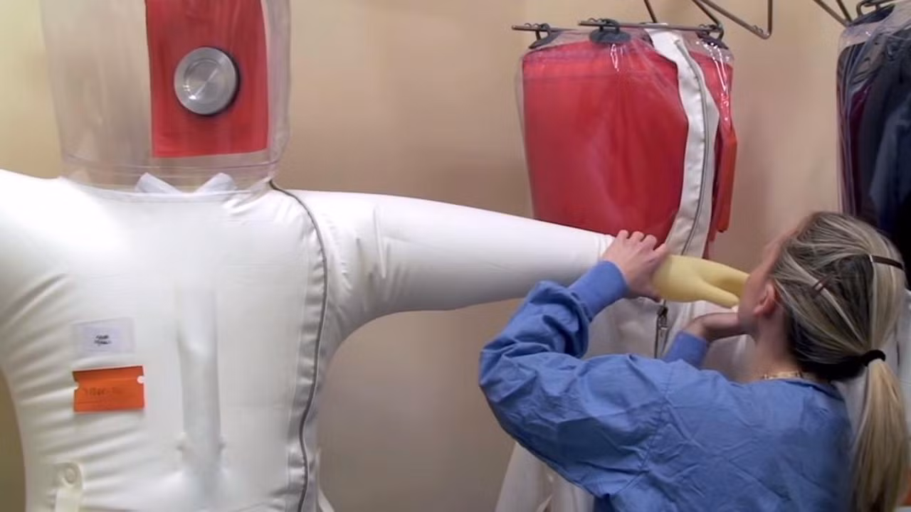 Thường xuyên kiểm tra bộ đồ bảo vệ áp lực dương xem có bị thủng hay không. Ảnh: NIAID.