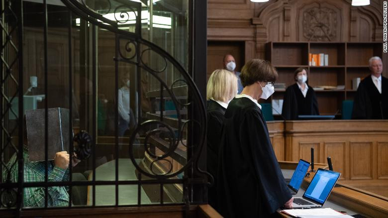 Bị cáo giết người với động cơ ăn thịt người che mặt bằng bìa cứng khi hầu tòa ở Berlin. Ảnh: Reuters. Bị cáo giết người với động cơ ăn thịt người che mặt bằng bìa cứng khi hầu tòa ở Berlin. Ảnh: Reuters.