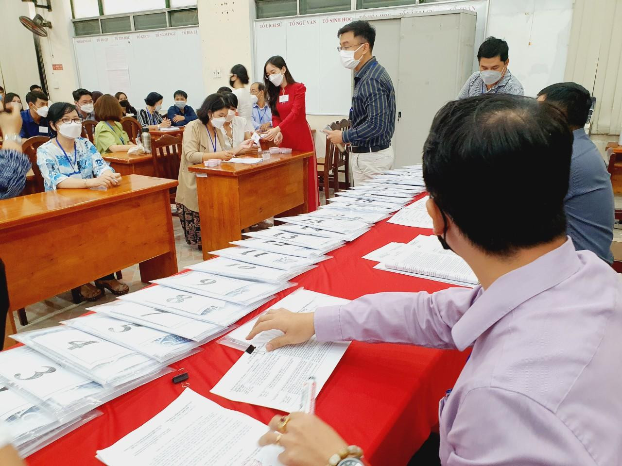 Tại phòng hội đồng thi, các cán bộ coi thi đang tập trung để nghe hướng dẫn và nhận đề thi.