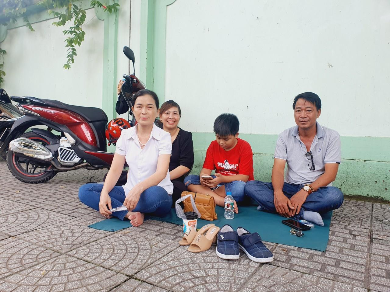 Cả gia đình ngồi chờ thí sinh đi thi. Ảnh: Nguyễn Dũng