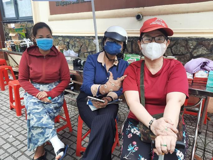 Chị Lê Thị Minh Tuyết (bên phải) ngồi cùng với các phụ huynh khác chờ con thi sáng 8-7 Chị Lê Thị Minh Tuyết (bên phải) ngồi cùng với các phụ huynh khác chờ con thi sáng 8-7