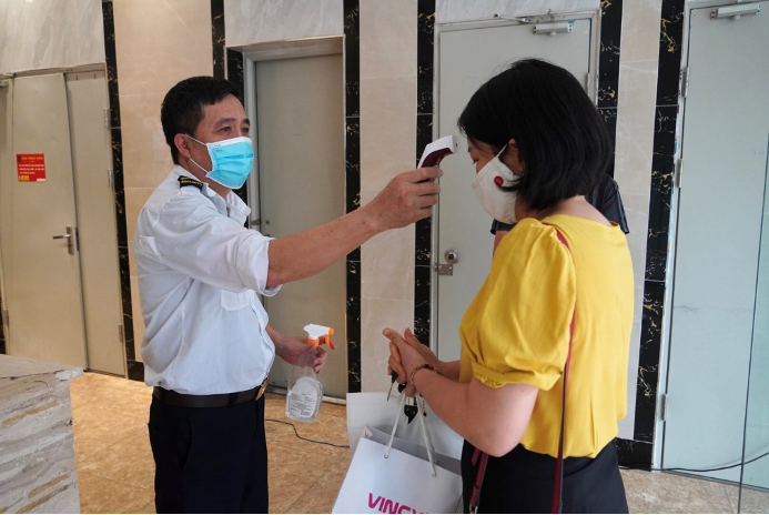 Bảo vệ túc trực 24/7 ở lối ra vào để kiểm tra sức khỏe người ra, vào chung cư