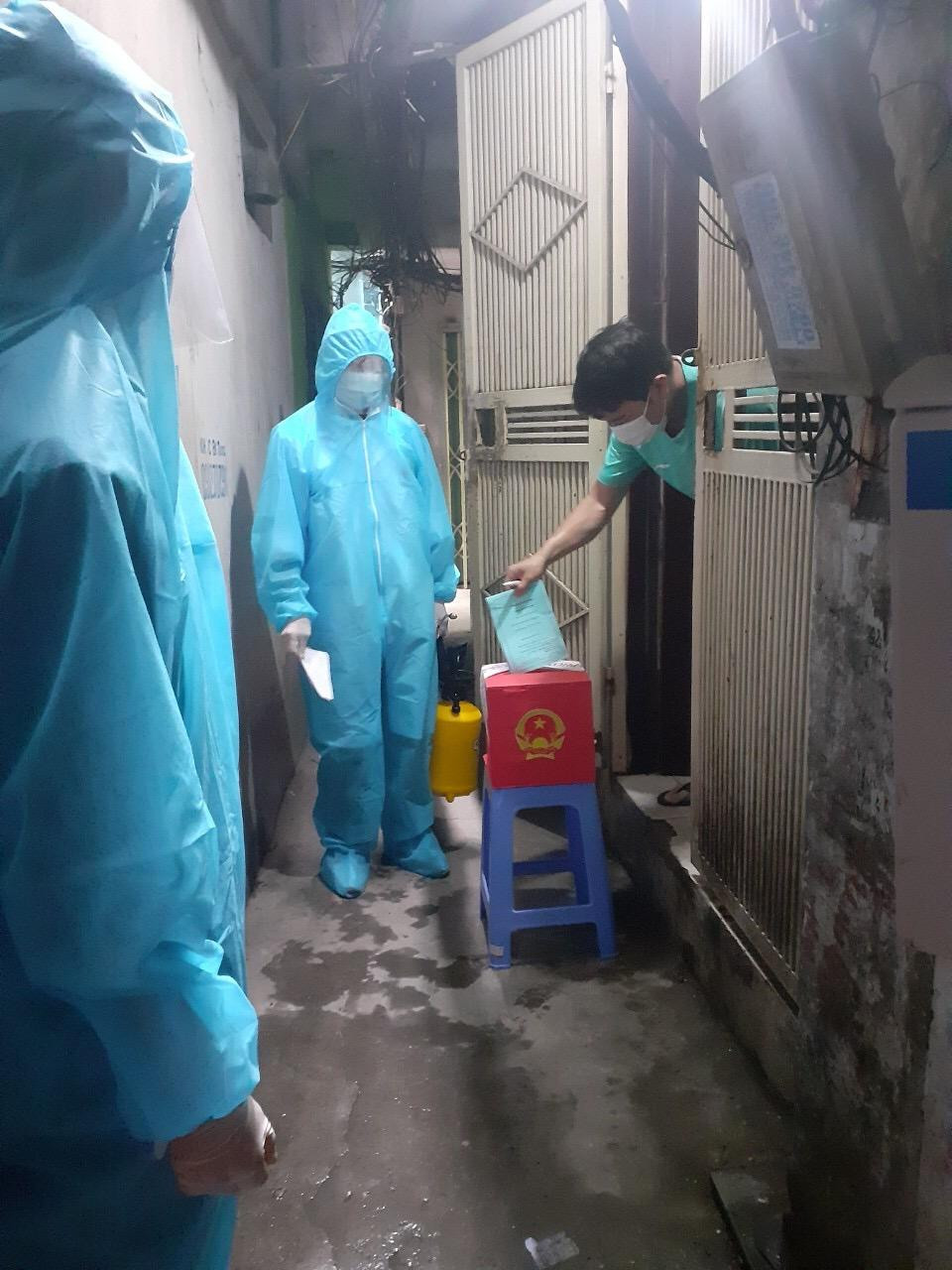 Tổ cơ động phường Ngọc Khánh tới nhà của cử tri đang thực hiện cách ly để họ thực hiện quyền bầu cử