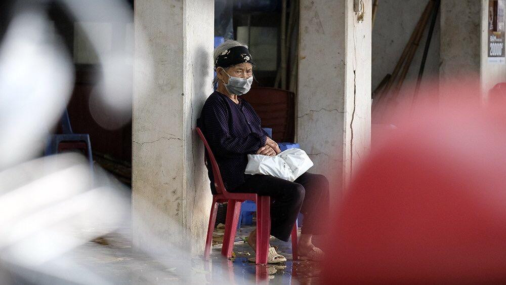 Bà cụ liên quan đến ca mắc COVID-19, năm nay đã 86 tuổi, ngồi đợi lấy mẫu xét nghiệm để đi cách ly tập trung. Ảnh: Hoàng Mạnh Thắng