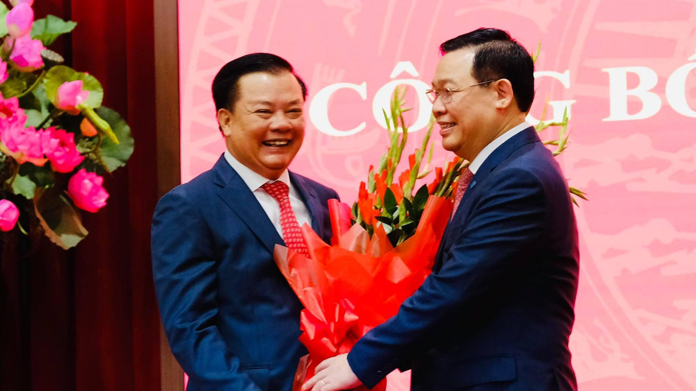 Chủ tịch Quốc hội Vương Đình Huệ chúc mừng tân Bí thư Thành uỷ Hà Nội Đinh Tiến Dũng. Ảnh: Mạnh Thắng