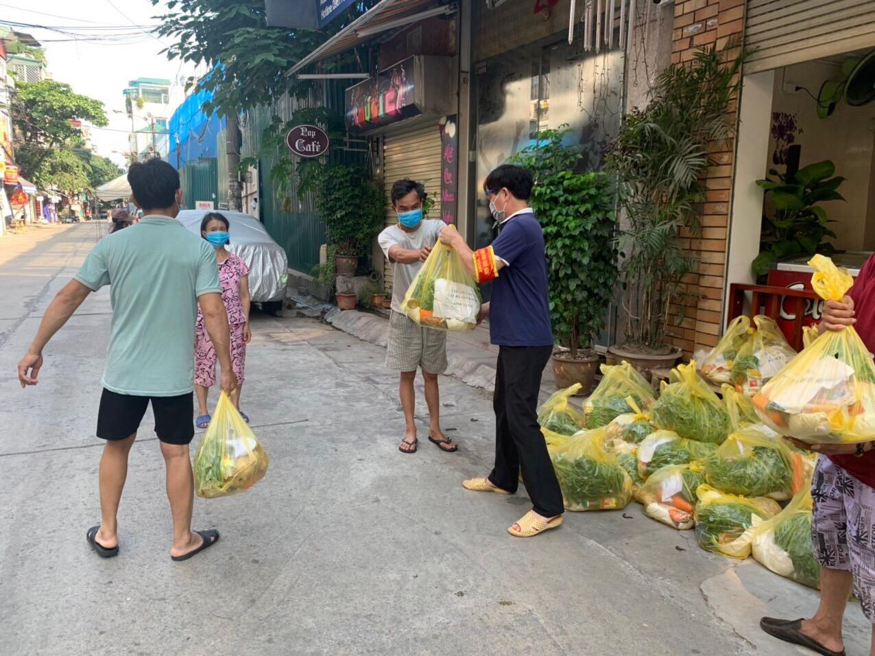 Người dân nhận các phần lương thực thực phẩm thiết yếu trong khu phong toả phường Chương Dương. Ảnh: PV