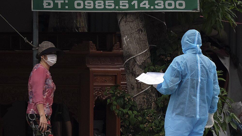 Một nhân viên y tế mặc đồ bảo hộ đi rà soát thông tin quanh khu vực thôn Kênh Đào. Ảnh: Hoàng Mạnh Thắng