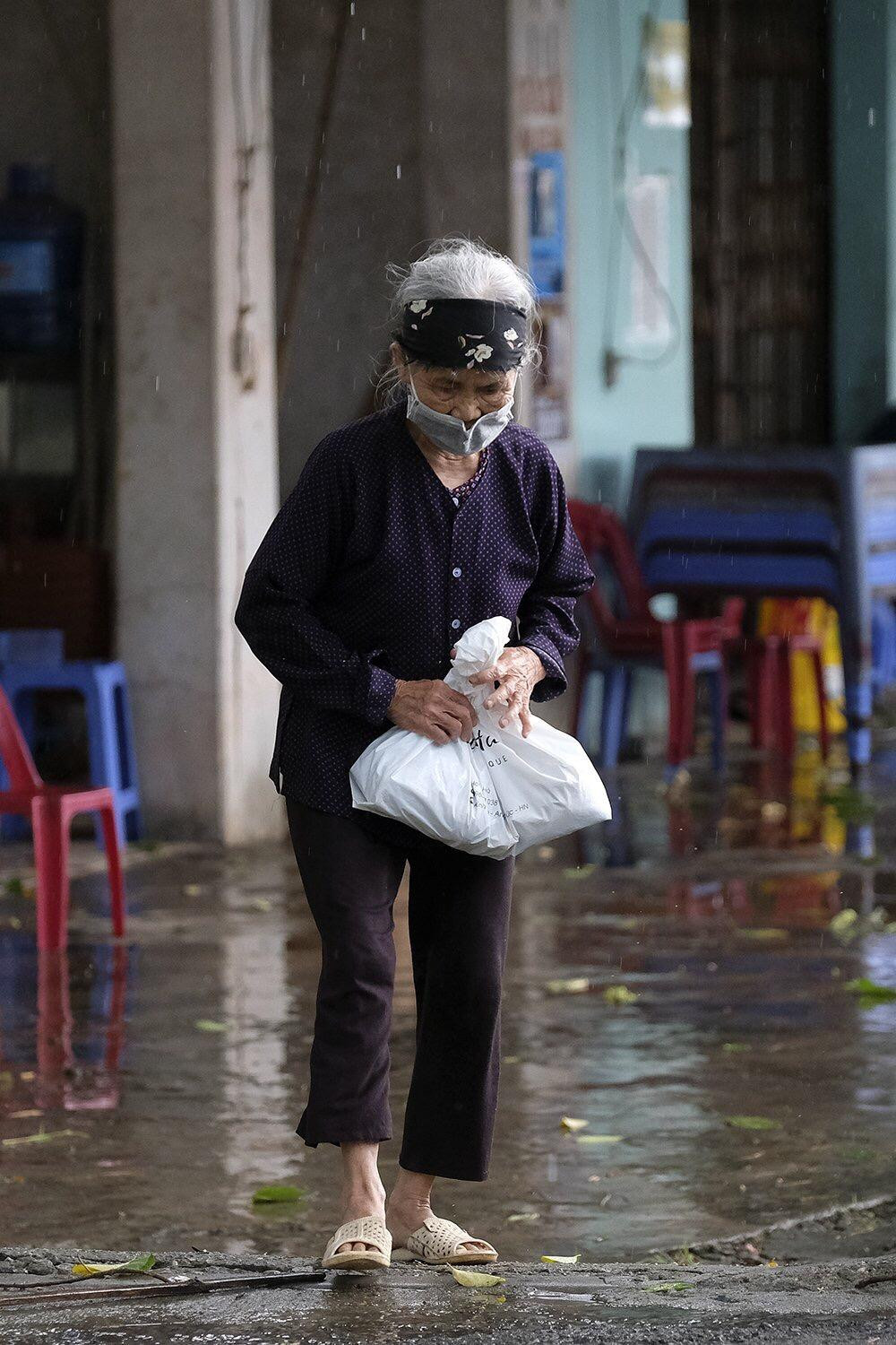 Sau khi lấy mẫu, bà cụ được lên xe ra về. Người nhà cụ cho biết, cụ bị say xe ô tô rất nặng, không thể di chuyển bằng ô tô. Tuổi cụ cũng đã cao, sợ say xe ảnh hưởng nặng nề đến sức khoẻ. Vì thế, lực lượng chức năng tạm thời cho cụ về nhà tự cách ly. Ảnh: Hoàng Mạnh Thắng