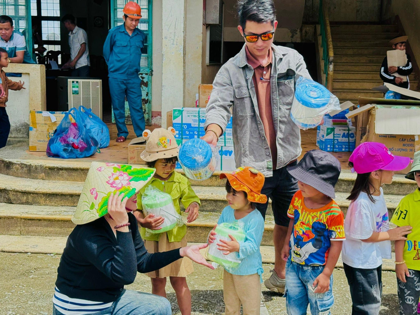 Các em học sinh nhận vở mới, cà mèn từ đoàn thiện nguyện