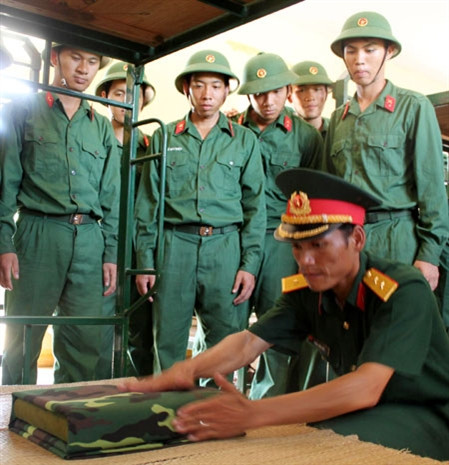 Những ngày đầu trong quân ngũ, chiến sĩ mới được hướng dẫn tỉ mỉ từ việc gấp chăn, màn… 