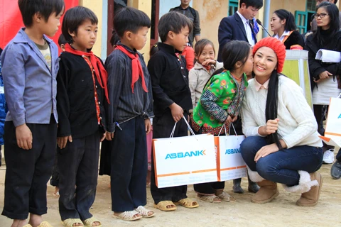 Trao quà xong, Ngọc Hân nhận được một “cái thơm” của em bé vùng cao. Ảnh: Trường Phong