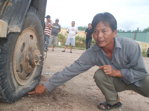 Ông Dương Rượu Em, một nông dân đến đòi nợ, chỉ vào vết đâm của nhóm thanh niên làm thủng lốp xe của ông