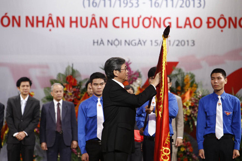 Đồng chí Đinh Thế Huynh, Ủy viên Bộ chính trị, Bí thư Trung ương Đảng, Trưởng Ban Tuyên giáo Trung ương gắn Huân chương lên cờ truyền thống của báo Tiền Phong