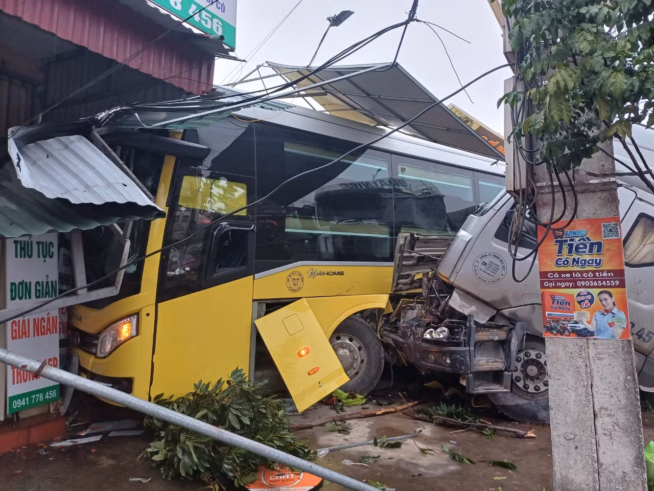 Sau va chạm, xe đầu kéo đẩy ép xe khách lao vào nhà dân. Sau va chạm, xe đầu kéo đẩy ép xe khách lao vào nhà dân.