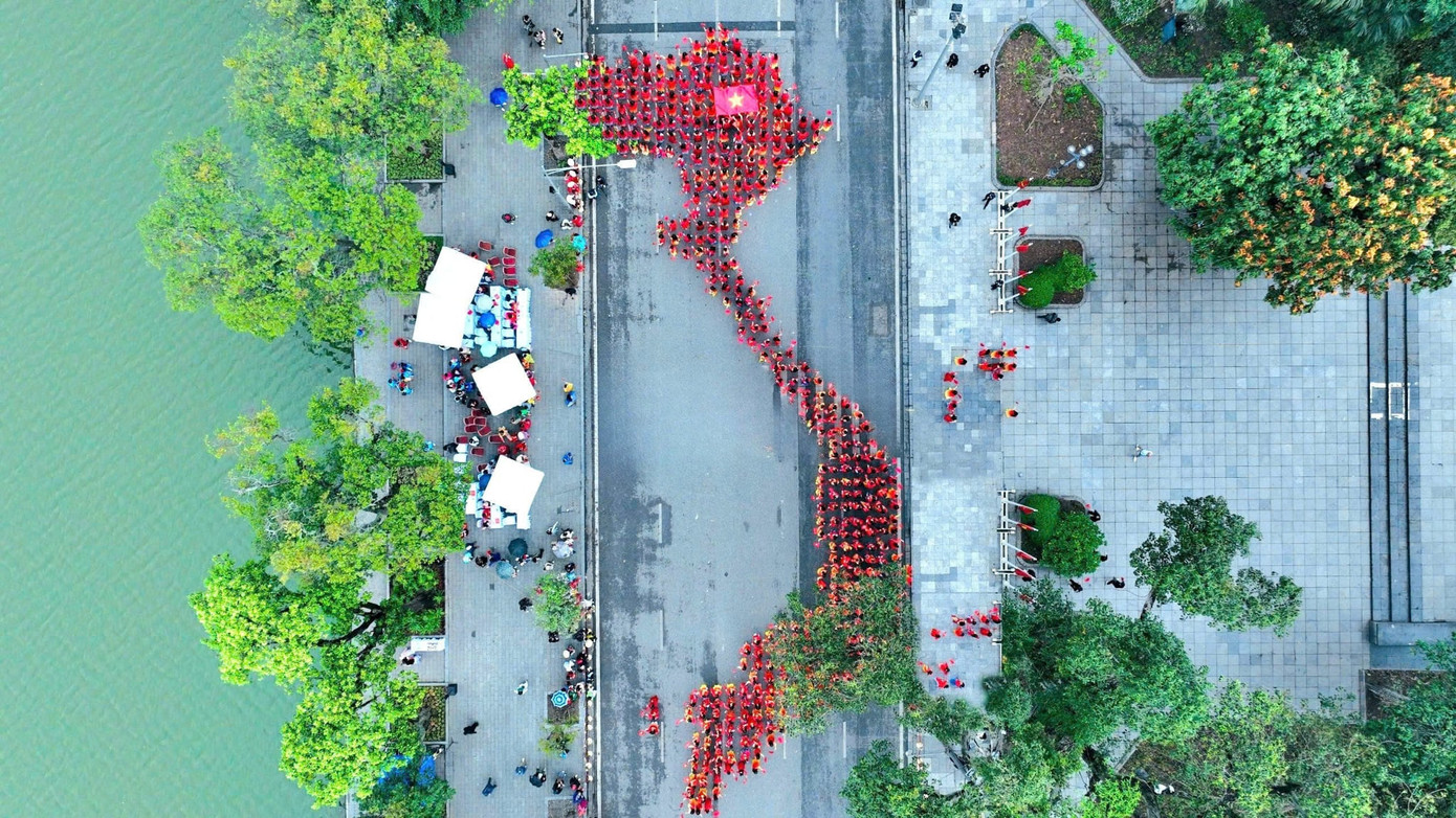 Phần xếp hình áo dài bản đồ Việt Nam do 500 nữ sinh viên Học viện Phụ nữ Việt Nam trong trang phục áo dài cờ đỏ sao vàng thực hiện. Hình ảnh hàng trăm các bạn nữ trẻ trong trang phục áo dài cờ Tổ quốc xếp hình bản đồ Việt Nam không chỉ là một biểu tượng của tinh thần đoàn kết mà còn là lời khẳng định về vai trò quan trọng của các lực lượng phụ nữ trong việc gìn giữ, phát triển đất nước. Phần xếp hình áo dài bản đồ Việt Nam do 500 nữ sinh viên Học viện Phụ nữ Việt Nam trong trang phục áo dài cờ đỏ sao vàng thực hiện. Hình ảnh hàng trăm các bạn nữ trẻ trong trang phục áo dài cờ Tổ quốc xếp hình bản đồ Việt Nam không chỉ là một biểu tượng của tinh thần đoàn kết mà còn là lời khẳng định về vai trò quan trọng của các lực lượng phụ nữ trong việc gìn giữ, phát triển đất nước.